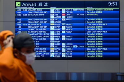 An arrival board showing cancelled flights at Tokyo's Haneda Airport on Tuesday. The spread of Covid-19 has resulted in major travel disruptions. Photo: AFP
