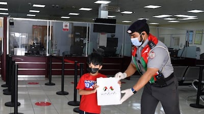 A boy from Oman gets a gift bag from an Abu Dhabi Police official.