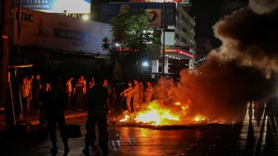 Lebanese army soldiers stand guard as smoke rises from tyres set on fire by demonstrators during a protest, after Lebanon's Central Bank said it would stop bank withdrawals from dollar accounts at low fixed rate, in Antelias, Lebanon, on Thursday. Reuters