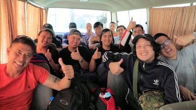 Crew rejoice as they travel on a bus after being released by the Houthis. Reuters