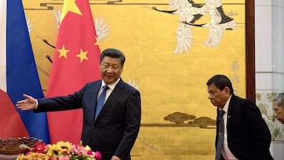 Philippine president Rodrigo Duterte, right, is shown the way by Chinese President Xi Jinping before a signing ceremony in Beijing. Ng Han Guan / AP Photo