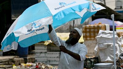 A man sets up a parasol for shade in New Delhi. The heatwave has been attributed to continuous dry weather in the second half of May. AFP