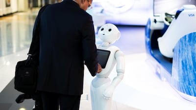A visitor shakes hands with Pepper the robot in Dubai. The UAE's four main financial regulators jointly published a consultation paper on proposed new rules governing the use of technology in financial services. Reem Mohammed / The National