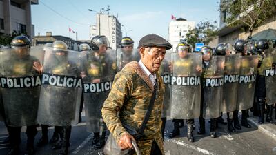 A man walks in front of police officers during a protest against rising crime levels in Lima, Peru. EPA
