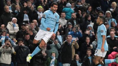 Manchester City's Carlos Tevez celebrates his goal against Swansea with Gael Clichy. Lindsey Parnaby/EPA