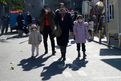 People wear masks outside a children's hospital in Beijing. Reports suggest medical centres are overwhelmed with the surge in respiratory illnesses. AP