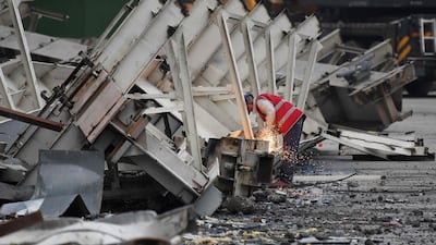 A worker cuts up steel during demolition of the Workers' Stadium in Beijing. AFP