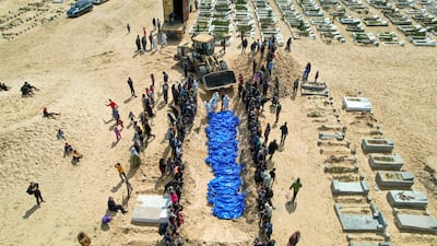 Medical personnel prepare the bodies of 47 Palestinians during a mass funeral in Rafah in the southern Gaza Strip on March 7, 2024. Israeli forces have returned 84 exhumed bodies from Gaza cemeteries to Palestinian authorities. AFP