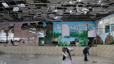 Men clean a damaged wedding hall after a blast in Kabul. Reuters