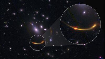 The galaxy cluster MACSJ 0138. The magnified section shows a bright orange-red dot, which traces cold dust observed in radio waves, using the Alma array. PA