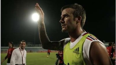 David Beckham of A.C. Milan Football team, waves to fans as he leaves practice at Al Nasr football club in Dubai.