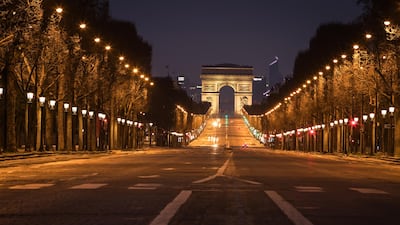 Street lights illuminate a deserted Champs-Elysees leading to the Arc de Triomphe monument in central Paris on March 21, 2020. AFP