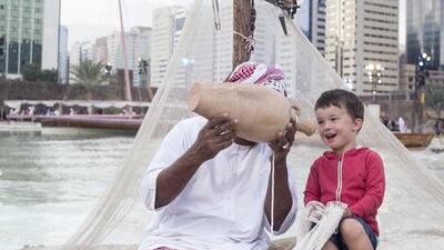 A fisherman teaches a little boy about his craft. Reem Mohammed / The National