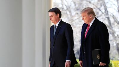 President Donald Trump and visiting Brazilian President Jair Bolsonaro walk along the Colonnade of the White House, March 19, 2019, in Washington. AP Photo