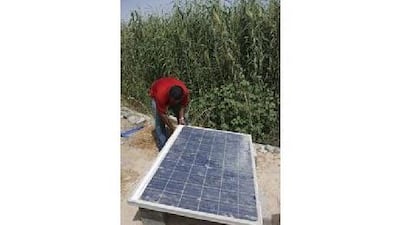 Shivaraman, a foreman, secures a solar panel to test the temperature range of the panel while it remains covered with dust at Waagner Biro Gulf in Ras al Khor, Dubai.