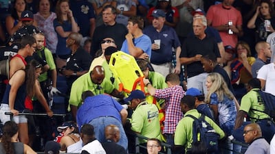 Emergency medical personnel attend to an injured fan in the stands at Turner Field during a baseball game between Atlanta Braves and New York Yankees Saturday, Aug. 29, 2015, in Atlanta. A fan fell from the upper deck into the lower-level stands at Turner Field on Saturday night and he later died from his injuries. (AP Photo/John Bazemore)