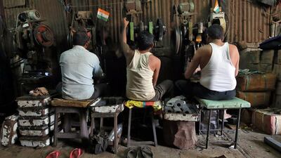 Workers operate metal cutting machines inside a workshop in Mumbai. Reuters