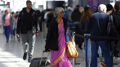 A woman walks with her luggage as passengers queue to enter airport security, at Terminal 5 of Heathrow Airport, in London, Britain. London is one of the destinations that has seen a steep rise in the cost of flights to. Reuters