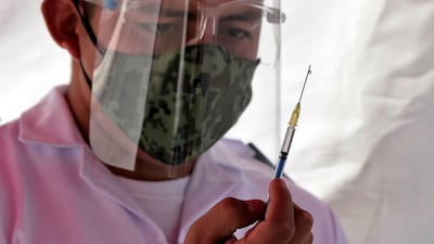 Medical staff administer the Pfizer/BioNTech vaccine against the coronavirus, at the Military Field Number 1A in Mexico City. Mexico will first apply the vaccine to all health personnel and the elderly as part of their mass immunization program. AFP