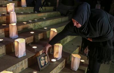 Mother of victim Nazira Al Tartousi fixes her picture next to candles during a sit-in in front of the national museum in Beirut. Al Tartousi, 15, was found dead with a bullet in her neck. Nabil Mounzer / EPA