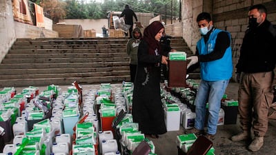 A Syrian refugee receives sanitisation and cleaning supplies from a representative of the United Nations High Commissioner for Refugees (UNHCR) in the city of Sidon in southern Lebanon. AFP