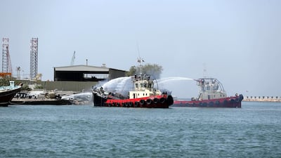 Firefighters tackle a fire on a boat in Sharjah's Khalid Port on Wednesday. Chris Whiteoak / The National