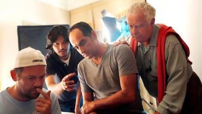 Navid Negahban, second from right, on the set of 51 at Emirates Palace in the capital this June. Satish Kumar / The National