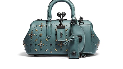 A dark teal design is decorated with metallic beads