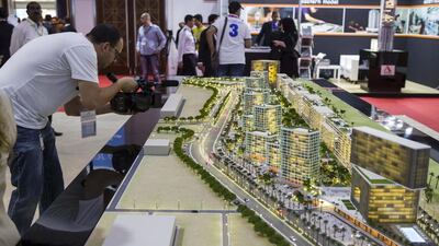 A visitor takes a video of a model of the planned Midtown development on display at the Deyaar stand. Antonie Robertson / The National