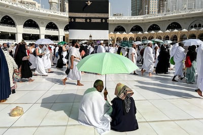 Pilgrims shelter from the heat under a parasol as worshippers gather around the Kaaba, Islam's holiest shrine, at the Grand Mosque in Saudi Arabia's holy city of Makkah. AFP