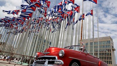 A classic American convertible car passes beside the US embassy. AP