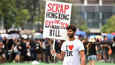 A protester holds up a placard as people gather ahead of a new rally against a controversial extradition law proposal in Hong Kong. AFP
