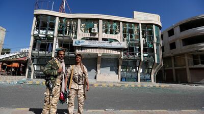 Houthi fighters pose for a photo in front of a damaged building on a street in Sanaa on December 6, 2017. Khaled Abdullah / Reuters