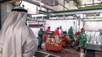 Customers wait for their purchased livestock to be processed by slaughter house workers.