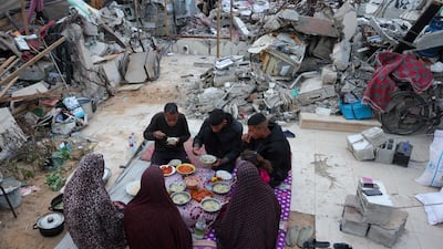 A Palestinian family eats an iftar meal outside their tent in Gaza. AFP