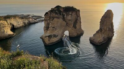 A man rides his jet ski as he passes under the landmark Rock of Raouche, also known as Pigeons' Rock, in Beirut. AP Photo
