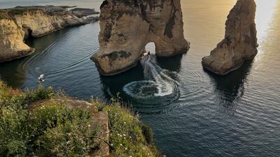 A man rides his jet ski as he passes under the landmark Rock of Raouche, also known as Pigeons' Rock, in Beirut. AP Photo