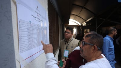A Palestinian assesses a candidate list at a polling station during municipal elections in Deir Al Balah. AFP