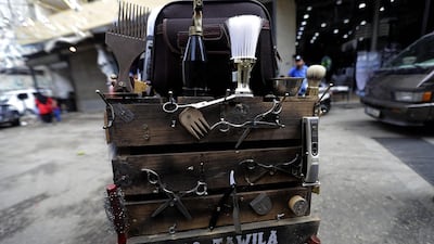 Everything he needs for a trim on the pavement is in a handmade trunk attached to the back of his pushbike: scissors, combs, electric razors and brushes. Joseph Eid / AFP