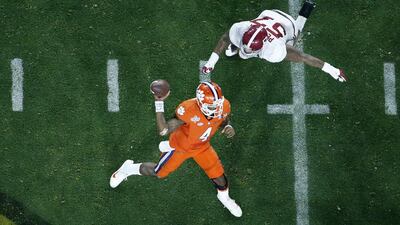 Clemson's Deshaun Watson (4) throws while being rushed by Alabama's D.J. Pettway (57) during the second half of the NCAA college football playoff championship game Monday, Jan. 11, 2016, in Glendale, Ariz. (AP Photo/Ross D. Franklin)