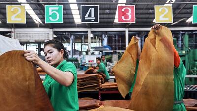 Employees trim smoked rubber sheets at the Thai Hua Rubber factory in Samnuktong, Rayong province in Thailand. Dario Pignatelli / Bloomberg