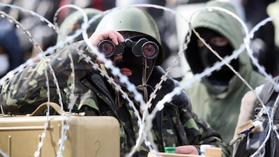 Pro-Russian activists guard a barricade set at the Ukrainian regional Security Service building on the eastern city of Donetsk. Alexander Khudoteply / AFP