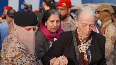 Saudi Navy personnel help a woman being evacuated from Sudan. Reuters