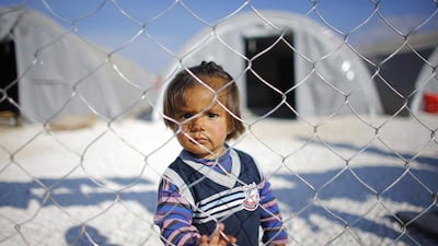 A Kurdish refugee boy from the Syrian town of Kobani looks on inside a fenced refugee camp in the border town of Suruc, Sanliurfa province. REUTERS / Osman Orsal