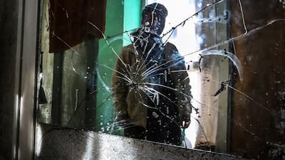 An Afghan boy look at the broken glass at the site of a rocket attack at a residential house in Kabul on December 12. EPA