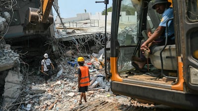 Heavy construction equipment is used to dig through the rubble as people look for survivors in a destroyed building in Mandalay, Myanmar. AFP