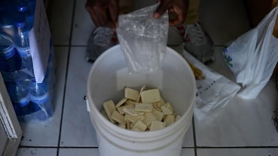 A hotel worker collects used soap in a hotel room in Port-au-Prince.