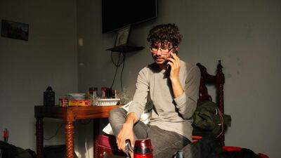 Zabih Afzali sits in his friends' office in Kabul making phone calls to get everything organised ahead of a trip to Bamiyan for a mountain expedition over the Eid holiday. Charlie Faulkner for The National