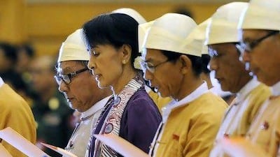 Myanmar opposition leader Aung San Suu Kyi, along with other elected members of parliament reads her parliamentary oath at the lower house of parliament during a session in Naypyidaw today.