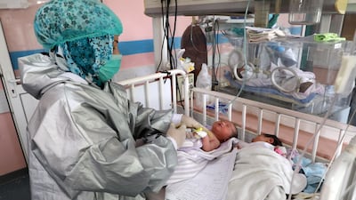 An Afghan nurse observes newborn children who lost their mothers during an attack at a hospital, in Kabul, Afghanistan. REUTERS